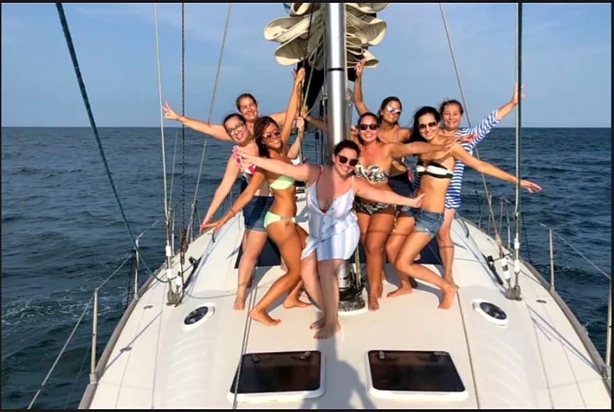 Grupo en la proa del velero frente a la costa